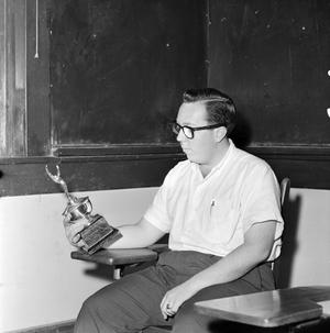 Primary view of object titled '[A debate club member holding a trophy #3]'.