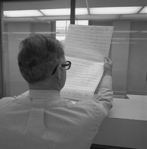 [Man reading a report, 3]