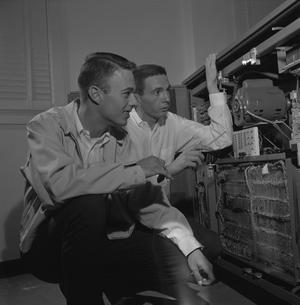 [Two men with an opened IBM 1620]