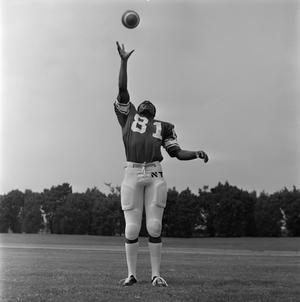 [Football player #81 from the 1971 season standing squarely with his right arm fully extended to the sky for an incoming football]