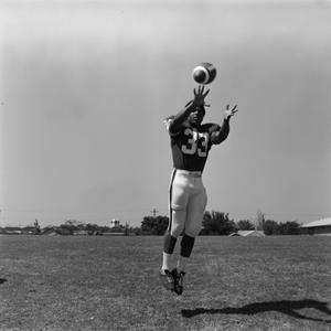 [Football player #33, Mike Franklin, mid air reaching for an incoming ball]