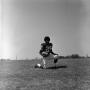 Photograph: [Football player #29, Joe Gilliam, posing on one knee cradling a foot…