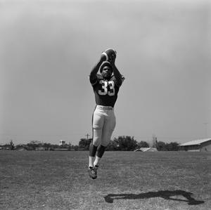 [Football player #33, Mike Franklin, catching a pass mid air]