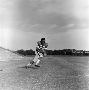 [Football player #28, David Jones, running to catch a ball in a stadium field]