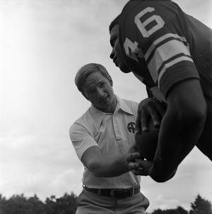 [Football coach standing with a player, 2]