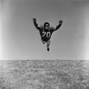 Primary view of object titled '[Football player #70, Jimmy Franklin, mid air tackle]'.