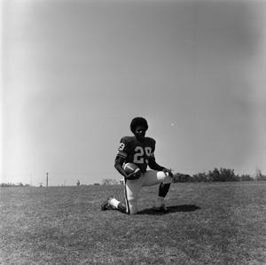 [Football player #29, Joe Gilliam, posing on one knee cradling a football]