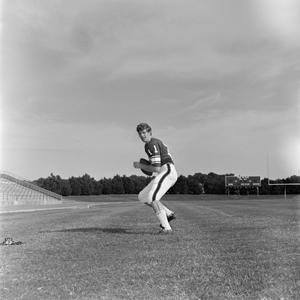 [Football player #11 Donald Poindexter from the 1971 season positioned in profile to throw a football]
