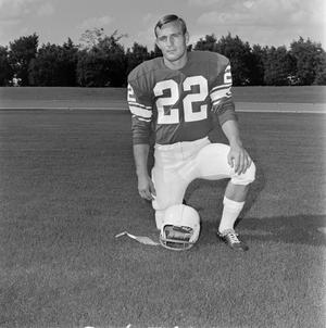 [Football player number 22 kneeling in a field]