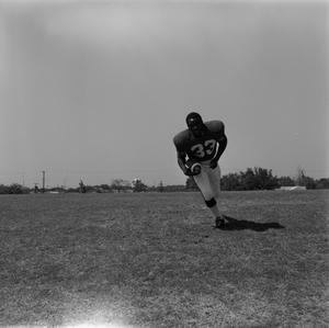 [Football player #33, Carl Hayes, carrying a football]