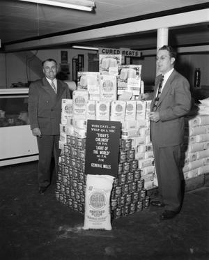 [Two men with a General Mills flour display]