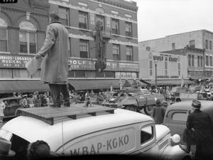 [Soldiers pass reporter standing on a vehicle, 2]
