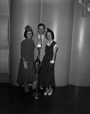 [Frank Mills with two women behind a microphone]