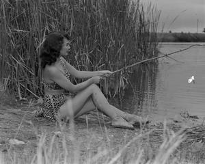 [Woman posing as Ghost River Kid while fishing]