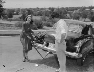 [Woman and man with car jack]