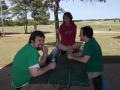 Photograph: [Three TNT members at picnic table]