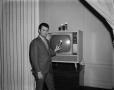 Photograph: [Allen Lee in front of a TV]