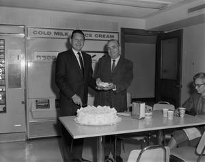 [Bob Gould and Roy Bacus share cake]