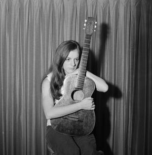 [Woman holding a guitar]