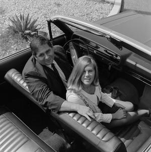 [Mike Hoey in an automobile with a woman]