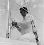 Photograph: [Man tying rope in sailboat]