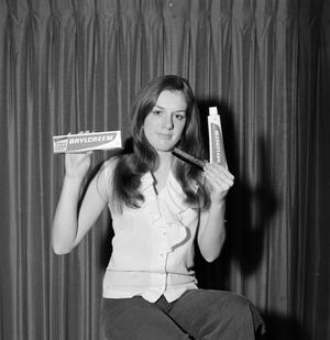 [Woman holding a comb and Brylcreem products]