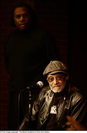 [Photograph of Melvin Van Peebles on stage in front of an unidentified man]