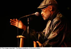 [Photograph of director Melvin Van Peebles as he speaks at a film festival]