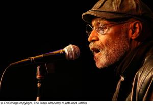[Photograph of a closeup of Melvin Van Peebles speaking into a microphone]