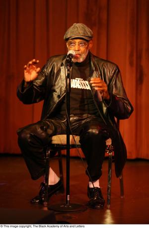 [Photograph of director Melvin Van Peebles talking on stage]