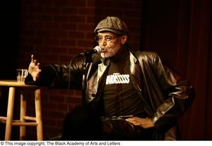 [Photograph of Melvin Van Peebles seated in front of an audience]