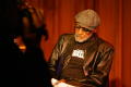 Thumbnail image of item number 1 in: '[Photograph of an individual filming Melvin Van Peebles on stage]'.