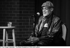 [Photograph of Melvin Van Peebles talking into a microphone]