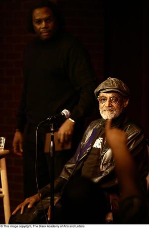 [Photograph of Melvin Van Peebles on a stage next to an unidentified man]