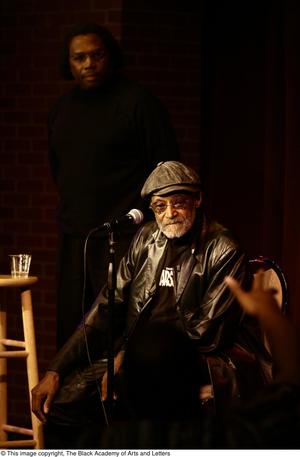 [Photograph of Melvin Van Peebles and an unidentified man on stage]