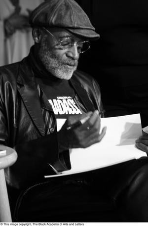 [Photograph of Melvin Van Peebles signing a book]