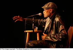 [Photograph of director Melvin Van Peebles speaking on a stage]
