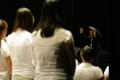 Photograph: [Choir members look towards the conductor]