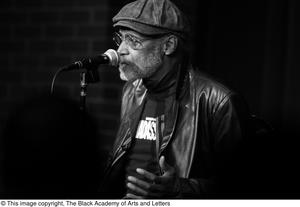 [Photograph of director Melvin Van Peebles seated on stage]
