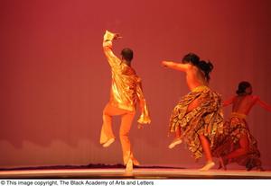 [Photograph of three dancers performing in orange outfits]