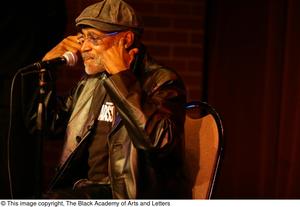 [Photograph of Melvin Van Peebles sitting on a stage at 24-Hour Film Feast]