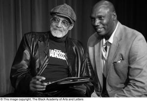 Primary view of object titled '[Photograph of a man posing with Melvin Van Peebles]'.