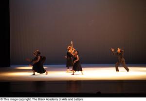 [Photograph of six dancers standing on stage in black clothing]
