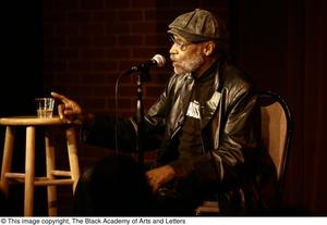 [Photograph of director Melvin Van Peebles talking on a stage]