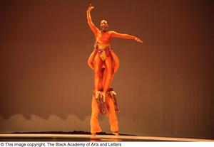 [Photograph of a dancer being lifted up on stage]