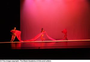[Photograph of three dancers holding a large strip of red fabric]