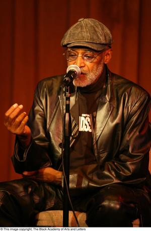 [Photograph of director Melvin Van Peebles as he talks on stage]