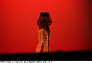 [Photograph of a man and woman embracing on stage]