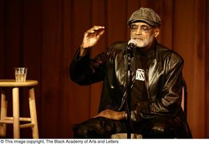 [Photograph of Melvin Van Peebles talking on stage at a film festival]