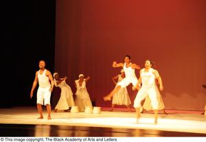 [Photograph of seven individuals dancing on a stage]